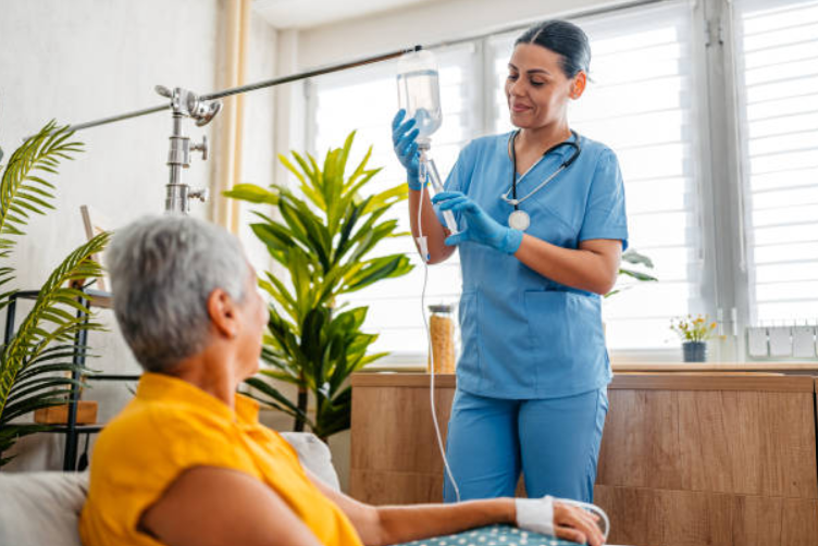 A medical caregiver administers Nootropic IV therapy to an elderly woman with care and precision.