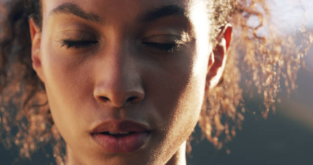 A close-up of a woman's face with her eyes closed, deep in concentration.