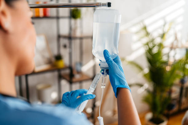 A nurse preps an IV bag with a hydration solution.